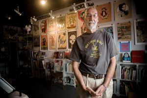 An eclectic mix of art, music and books surrounds Jerry Waddle in Ducky Waddle's Emporium in Leucadia, pictured May 29, 2015. The store is closing this month after 20 years in business. (NCC file photo by Jen Acosta)