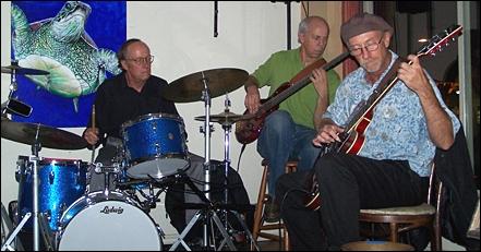 John Hall on drums (left), Lance Jeppesen on bass (center) and Joseph Angelastro on guitar perform Nov. 13 at E Street Cafe in Encinitas. (Photo by Scott Landheer)