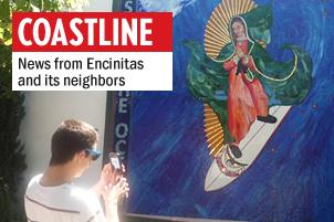 Leucadia resident Raymond Orate snaps a picture of the Surfing Madonna on June 26 at its new home, between Café Ipe and Surfy Surfy in the 900 block of North Coast Highway 101. The mosaic was installed on June 25 by artist Mark Patterson and a crew. (Photo by Ernesto Lopez)