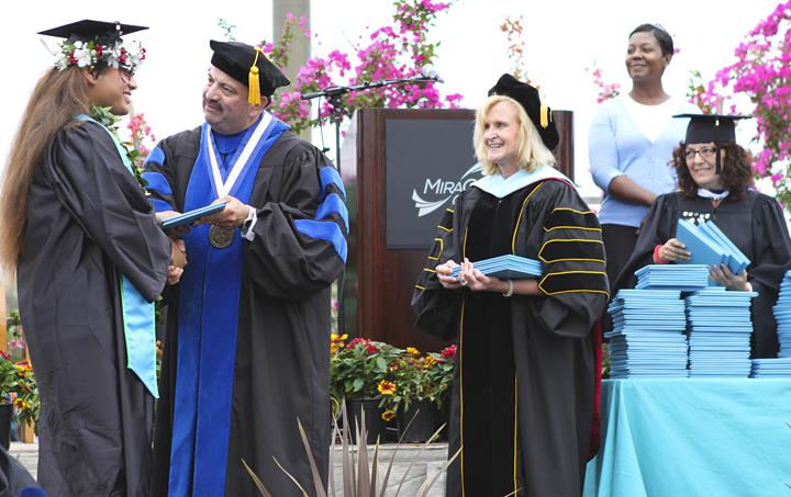 MiraCosta College Superintendent/President Francisco Rodriguez (left) congratulates a student as Vice President of Instructional Services Mary Benard (center) looks on during commencement ceremonies May 17. (Photo courtesy of MiraCosta College)