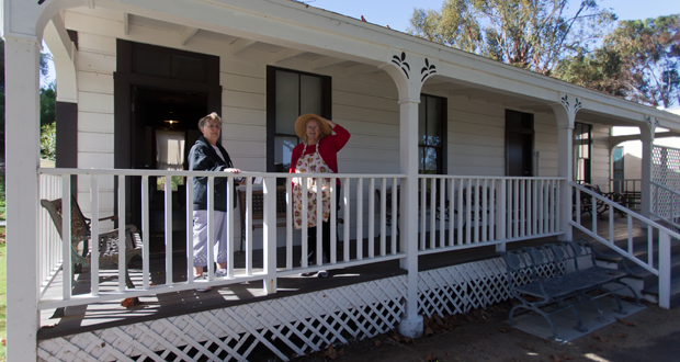Dottie Frank and Terry Larson on the porch of the Payne/Johannsen House at Heritage Park 