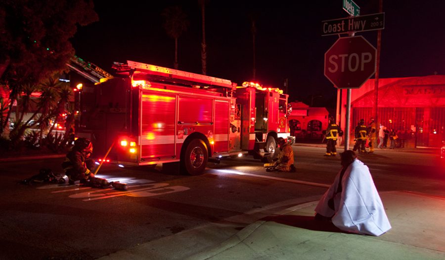 A Dolphin Hotel Resident, who's room the fire originated, sits huddled in a blanket as firefighters replace air-pac bottles.Photo: Steve Marcotte/OsideNews