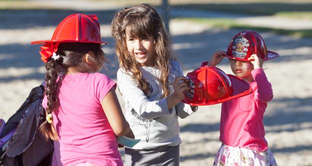 Ashanti, 5, Carolyn, 5 and Maybelle, 3 model their fire helmets at the Celebration of Life event at Libby Lake Park