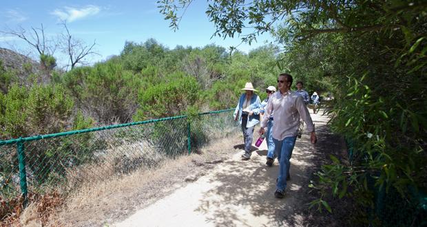 A group walks along the LaCosta Glen Trail which borders the new preserve area