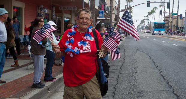 Senior of The Year Award  winner, Chris Gow passing out flags at the Oceanside Independence Parade in June