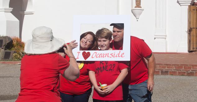 Michelle, Tyler, 13 and Ryan have their photo taken in front of the Mission before joining the group to form the heart