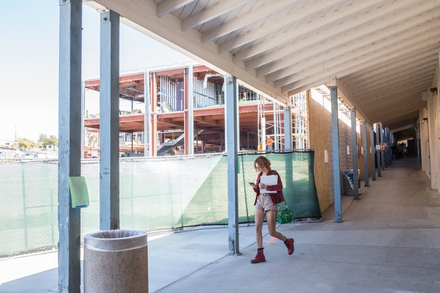 New construction looms over an original classroom building at San Dieguito High School Academy, built in the mid-1930s, as a student heads to class Sept. 15 at the Encinitas campus. (Photo by Jen Acosta)