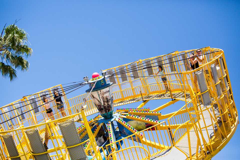 Spencer Howe and Natalie Boudin make a “hang loose” sign with their hands as they spin on the ride Round Up at The Encinitas Street Fair on April 30. The ride is roughly three minutes in duration and moves rapidly at high speed. (Photo by Cam Buker)