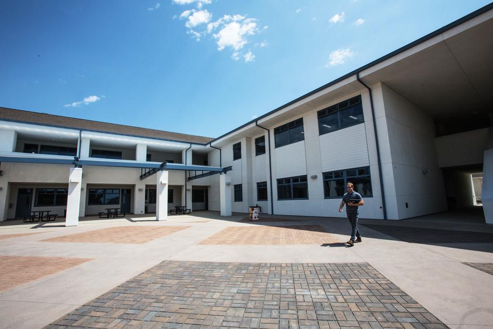 A faculty member walks across the courtyard of San Dieguito High School Academy's new math and science building Aug. 31. The complex opened with the start of the Encinitas campus' fall term. (Photo by Jen Acosta)