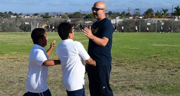 Laurel Elementary School Principal Freddie Chavarria high fiving students as they run laps (file photo)
