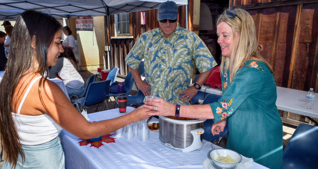 Mariah Lunschin gets a sample of Marc and Andrea Hermans first place chili.