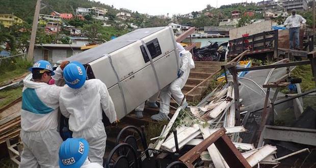 Corpsmembers remove water damaged belongings from inside a home in St. Thomas as the home owner watches
(Photo courtesy: California Conservation Corps)