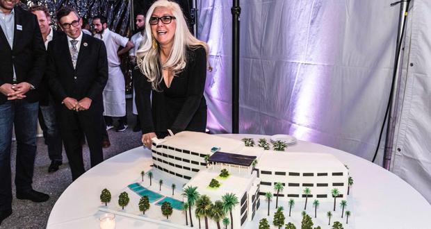 Dream Palm Developer Lauri Kibby cutting cake rendering. (photo courtesy: Dream Palm Springs)