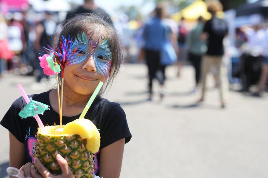 A young visitor to the Encinitas Spring Street Faire enjoys a piña colada April 29. (Photo by Jen Acosta)