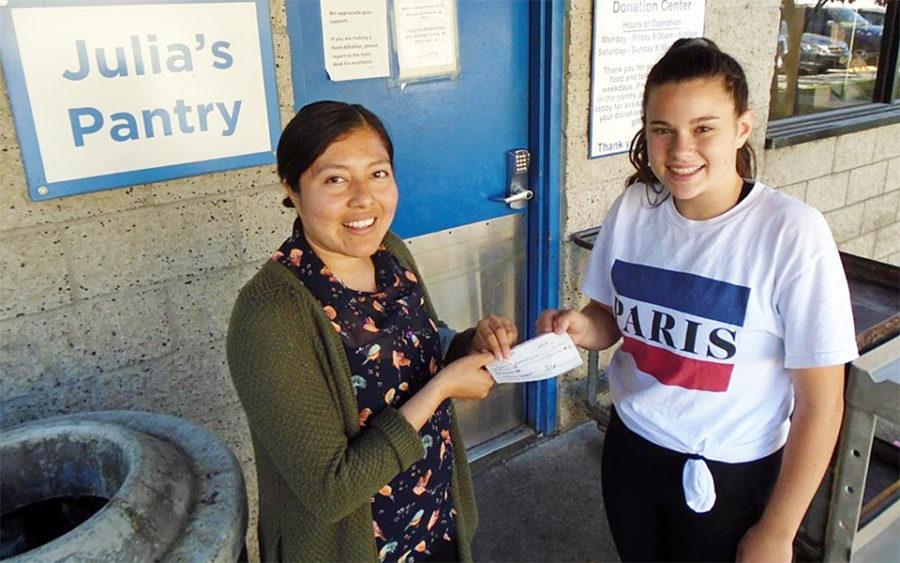 Rhoades School seventh-grader Kate Peterson delivers a check to Interfaith Community Services as part of her work in the school’s Change Makers elective program. (Rhoades School photo)