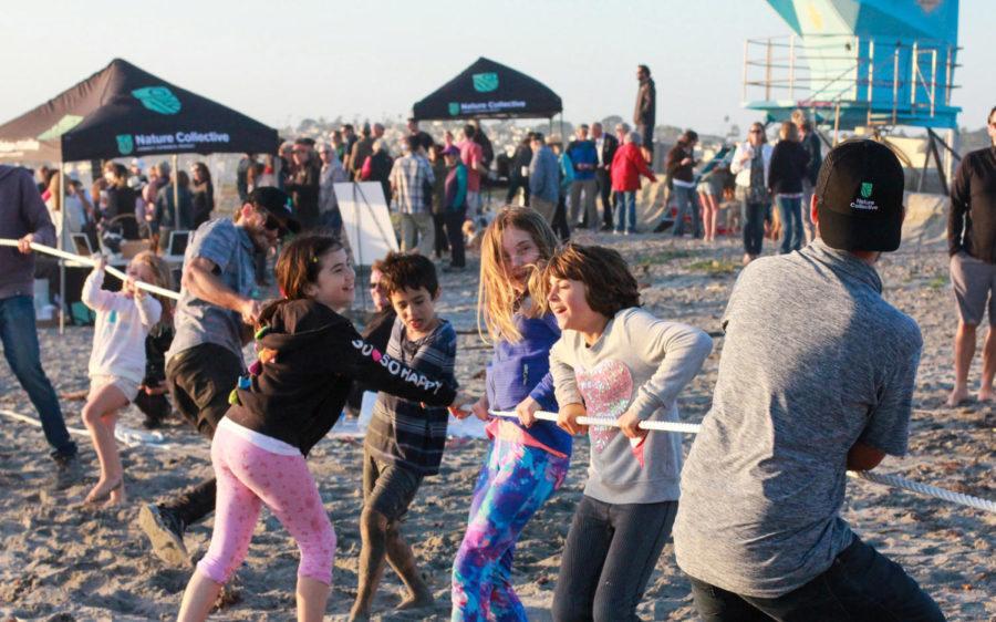 Kids lean in to a game of tug-of-war on the sands at Seaside Beach in Cardiff during the Nature Collectives unveiling celebration on May 17. (Nature Collective photo)