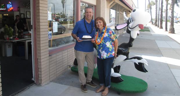 Todd Stephenson owner of Estate Warehouse in Oceanside will lead a dessert auction at the Brother Benno's "Ohana Luau." Linda Donahue,auxiliary co-chair, presents him with a pie. (courtesy photo)