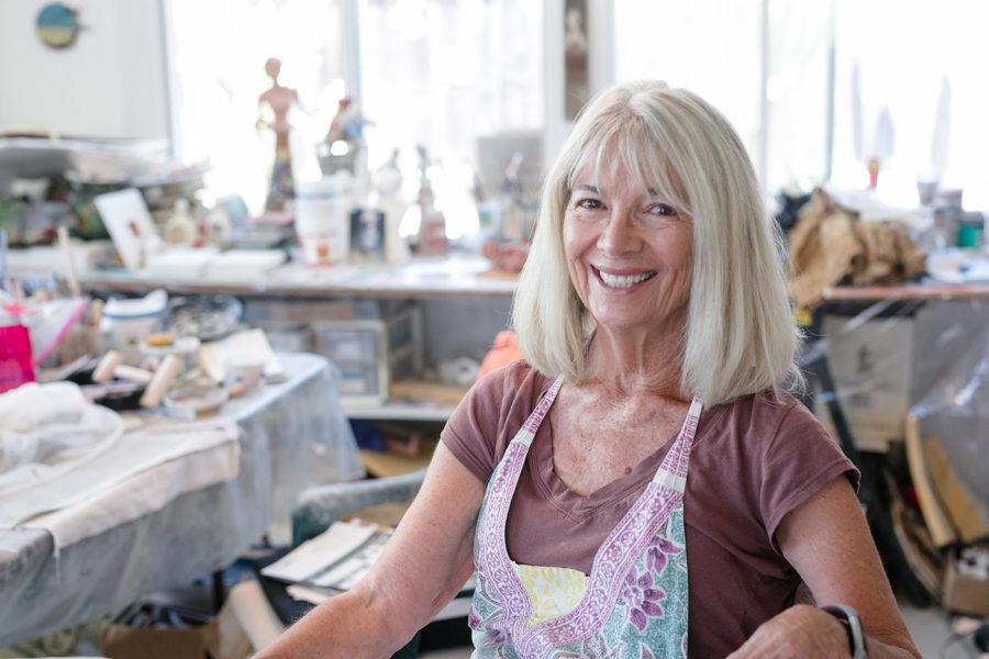 Encinitas artist Carla Funk sits among works in her studio July 2. (Photo by Jen Acosta)