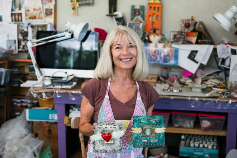 Encinitas artist Carla Funk shows two examples of work in her studio July 2. (Photo by Jen Acosta)
