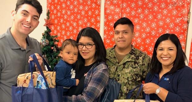 Community Development Officers, Joshua Rehhaut, School  (left) and Jennifer Walker (far right) distributing gift bags to a participating family (Photo courtesy: North Island Credit Union )