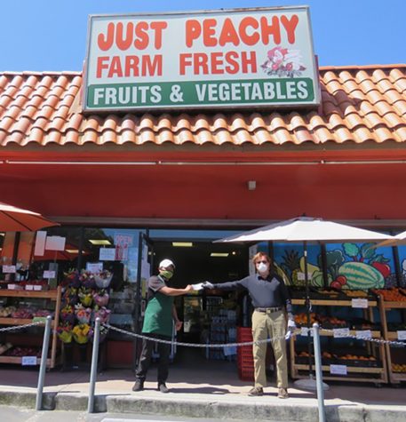 Robert Hemphill (right) delivers $500 checks to employees at Just Peachy Market in Leucadia on Wednesday, April 15, in recognition of the risks small businesses take in staying open during the COVID-19 coronavirus crisis. (Courtesy photo)