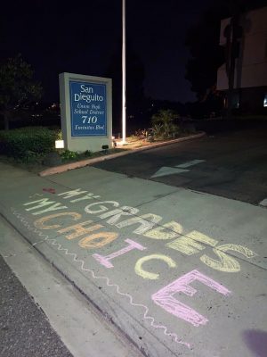 Columnist Marsha Sutton received this photo from a parent showing a protest slogan in chalk at the driveway of San Dieguito Union High School District headquarters in Encinitas. (Photo courtesy of Marsha Sutton)