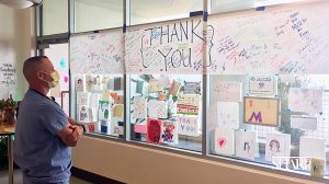 A Sharp COVID-19 caregiver looks at messages sent to the hospital’s personnel from Santa Fe Christian Schools fifth graders. (Sharp Health News photo)