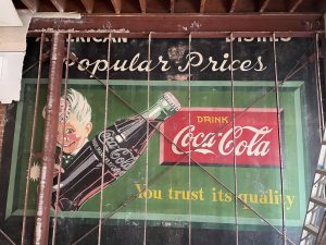 A Coca-Cola sign recently uncovered at Queen Eileen’s Gift Baskets in Encinitas features the “Sprite Boy” character, which appeared in Coca-Cola advertisements from in the 1940s and ’50s. (Courtesy photo)