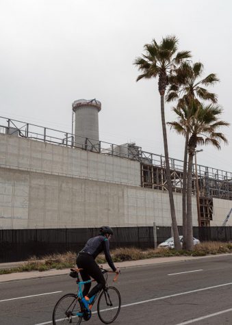 A cyclist heads south on Carlsbad Boulevard in front of the old Encina Power Station on April 10. (Photo by Jen Acosta)