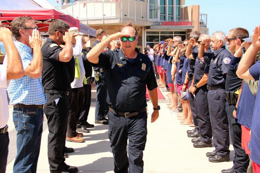 Encinitas Marine Safety Capt. Larry Giles salutes members of the city’s public safety agencies, including fellow lifeguards, during his retirement celebration Tuesday, July 20, at Moonlight Beach. (Photo courtesy of Scott Chatfield)