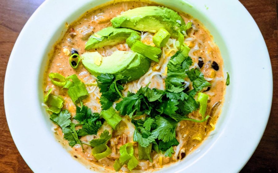 Toppings+take+this+homemade+enchilada+soup+to+divinity+status.+Creamy+avocado+sprinkled+with+lime+juice+and+salt%2C+crisp+tortilla+strips%2C+spicy+sliced+green+onions+and+fragrant+cilantro+make+this+soup+a+fiesta+in+a+bowl.+%28Photo+by+Laura+Woolfrey+Macklem%29