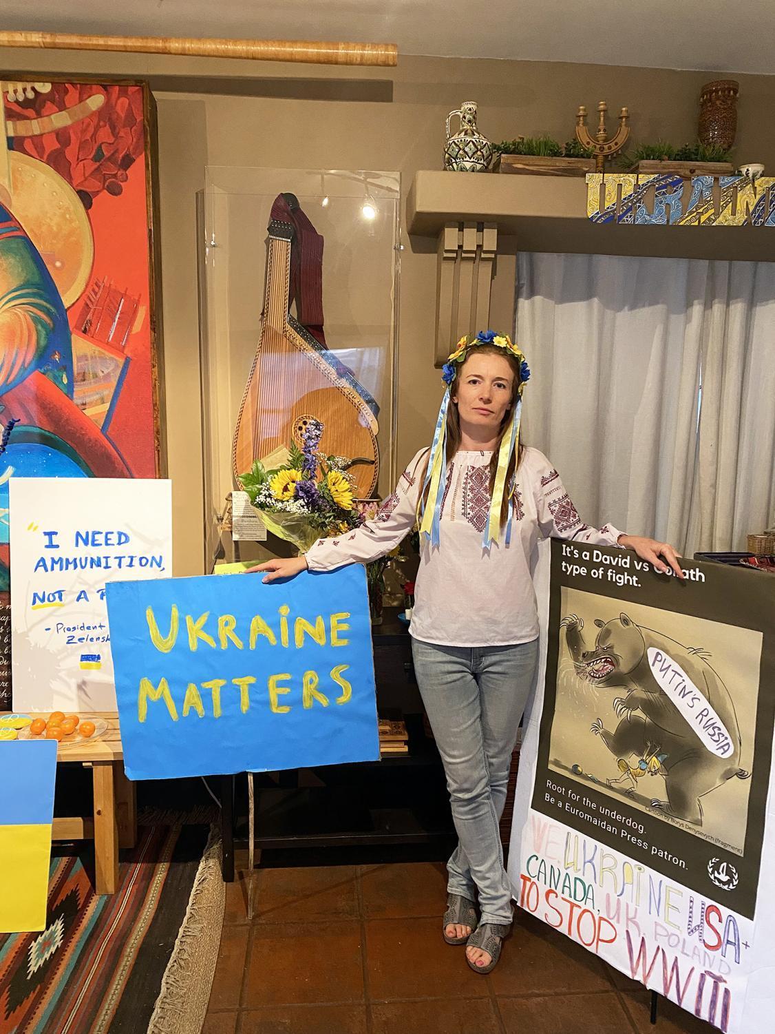 Mira Rubin, president of the House of Ukraine in Balboa Park, stands with posters used for anti-war rallies in San Diego in the weeks since Russia invaded Ukraine. (Photo by Roxana Becerril)