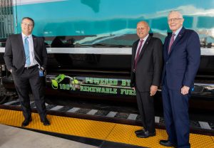 Metrolink CEO Darren Kettle (left), Metrolink board Chairman Ara Najarian (center) and Vice Chairman Larry McCallon (right) stand next to one of Metrolink’s locomotives, now powered by fully renewable fuel, on Wednesday, April 13, in Los Angeles. (Metrolink photo)