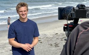 Project Moonlight founder and Encinitas lifeguard Jake Ratermann works on a promotional video for the organization on April 16. (Photo courtesy of William Roland)