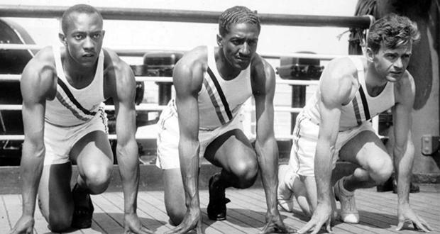 U.S. Olympic sprinters (from left) Jesse Owens, Ralph Metcalfe and Frank Wykoff do a light warm-up on the deck of the S.S. Manhattan before they sail for Germany to compete in the 1936 Olympics. (Public Domain image)