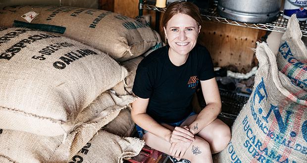 Old Cal Coffee Co. co-owner Erin Nenow sits among bags of beans she uses for her new Ascend Coffee Roasters business on Aug. 24. (Photo by Jen Acosta)