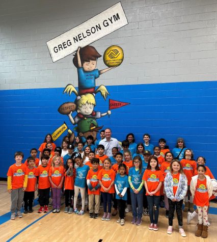 New Boys & Girls Clubs of Carlsbad CEO Chad Nelson (center, light blue shirt) stands with staff members and children in the gym that carries his father’s name. (Courtesy photo)