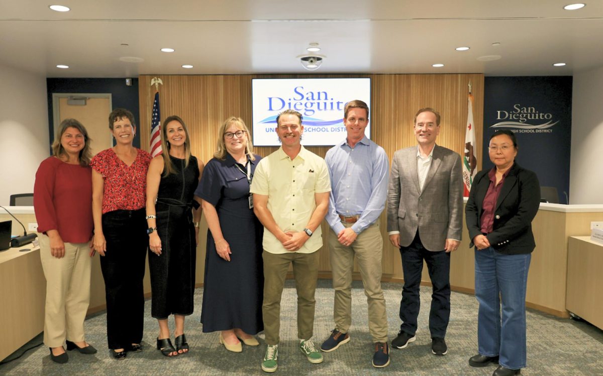 Pacific Trails Middle School physical education teacher Tyler Kuehl (center, yellow shirt) stands with members of the San Dieguito Union High School District Board of Trustees and other officials in May. (Courtesy photo)